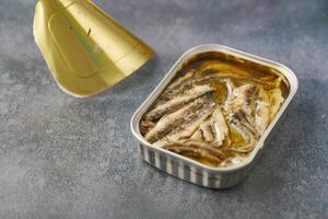 open blikje sardines op witte tegels achtergrond. foto