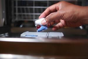 de persoon is gebruik makend van een zeep dispenser voor de vaatwasser met hun hand- foto