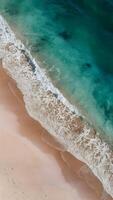 ai gegenereerd zacht zee Golf met schuim Aan zand strand, rustig kust verticaal mobiel behang foto