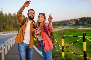 volwassen paar zijn gebruik makend van kaarten Aan smartphone in de stad. toeristen zijn bezienswaardigheden bekijken in de stad. foto