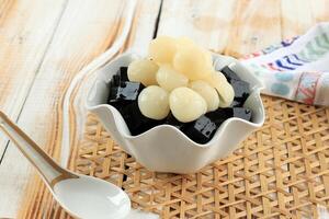 zwart gras gelei mesona chinensis met fruit longan topping. foto