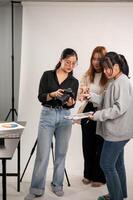 een vrouw fotograaf is pratend en tonen afbeeldingen Aan de camera naar haar team, werken in de studio foto