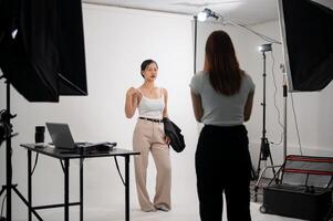 een professioneel fotograaf is nemen afbeeldingen van een aantrekkelijk jong Aziatisch vrouw model- in een studio foto