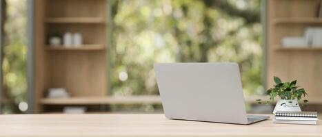 terug visie beeld van een laptop computer Aan een houten tafel in een hedendaags privaat kantoor. foto