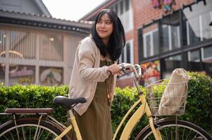 een vrouw gaan naar een supermarkt met haar fiets. een vrouw reiziger verkennen de stad met een fiets. foto