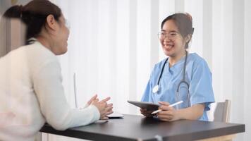 een professioneel Aziatisch vrouw dokter is overleg plegen een vrouw geduldig in de kantoor Bij de ziekenhuis. foto
