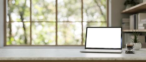 een wit scherm laptop model, een koffie beker, en een smartphone Aan een tafel in een modern huis kantoor. foto