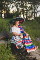 vrouw met Mexicaans hoed in landelijk landschap. cinco de mayo viering in Mexico. foto