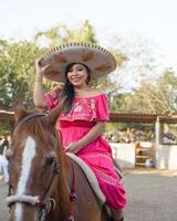 Mexicaans vrouw vervelend traditioneel jurk en charro hoed Aan paard. cinco de mayo viering. foto
