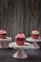 cupcakes Aan klein keramisch bord met houten bodem met kopiëren ruimte. Product foto. foto