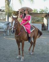 Mexicaans vrouw vervelend traditioneel jurk en charro hoed Aan paard. cinco de mayo viering. foto