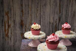 cupcakes Aan klein keramisch bord met houten bodem met kopiëren ruimte. Product foto. foto