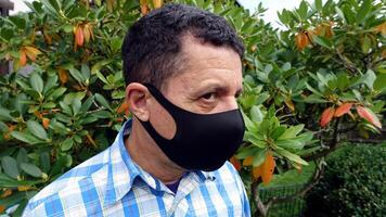 beeld beeltenis de gezicht van een Mens met een zwart beschermend anti-besmetting masker foto