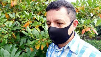 beeld beeltenis de gezicht van een Mens met een zwart beschermend anti-besmetting masker foto