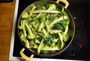 broccoli besnoeiing en zetten in een pan met olie en ui foto