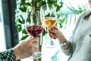 Mens en vrouw roosteren met wijn bril Bij een avondeten partij foto