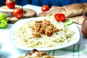 wit bord met pasta en vlees foto