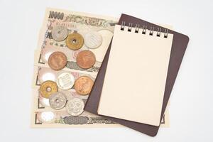 blanco papier kladblok en Thais paspoort met Japans geld. vakantie, planning begroting. reizen plan concept. foto