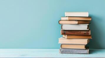 stack van verschillend boeken vooraan van een licht blauw achtergrond met kopiëren ruimte foto