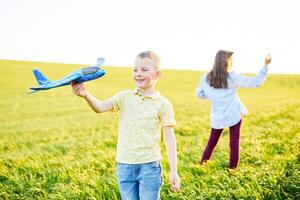 vrolijk en gelukkig kinderen Speel in de veld- en stel je voor zich naar worden piloten Aan een zonnig zomer dag. kinderen dromen van vliegend en luchtvaart. foto