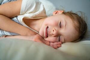 schattig weinig meisje slapen en slijpen tanden in dromen, gebalde tanden met vermoeidheid en spanning. hoog kwaliteit foto