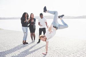 straatartiest breakdance buitenshuis. verraste vrienden applaudisseren foto