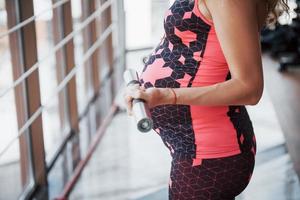 conceptie van zwangerschap, sport, fitness en een gezonde levensstijl in de sportschool. foto