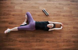 concept van yoga en fitness zwangerschap. portret van een jong model van een zwangere vrouw die zich binnenshuis ontwikkelt.