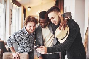 vrolijke oude vrienden communiceren met elkaar en bellen in de kroeg. concept van entertainment en levensstijl. wifi verbonden mensen in bartafelvergadering foto