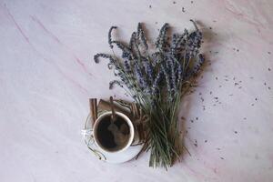 een kop van koffie met kaneel en lavendel bloem Aan een tafel. foto