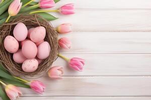 Pasen vakantie viering banier groet kaart banier met roze geschilderd eieren in vogel nest mand en geel tulp bloemen Aan wit houten achtergrond tabel textuur. foto