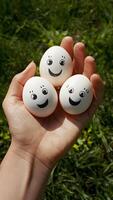 hand- Holding drie eieren met grappig gezichten, bevorderen gezond aan het eten verticaal mobiel behang foto