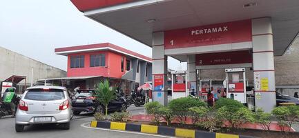 wachtrij van voertuigen openbaar tanken Bij pertamina gas- station of pom bensin gedurende de dag. bekasi, west Java, Indonesië - april 4 2024 foto