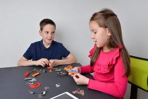 jongen en meisje werk samen Aan een robot projecteren, verstrengeling aan het leren met sociaal wisselwerking foto