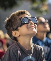 een jong jongen vervelend beschermend bril is aan het kijken de zonne- verduistering. foto