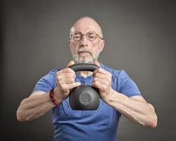 senior Mens oefenen met ijzer kettlebell foto