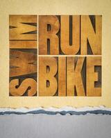 rennen, fiets, zwemmen - triatlon concept, woord abstract in wijnoogst boekdruk hout type Aan kunst papier, sport en recreatie concept foto