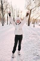 senior vrouw in witte hoed en bontjas genieten van de winter in het sneeuwbos. winter, leeftijd, seizoen concept foto