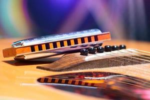 detail van gitaarsnaren met ondersteunde mondharmonica voor countrymuziek foto