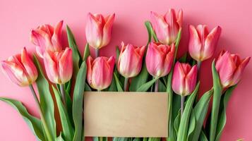mooi roze tulis met blanco kaart Aan zacht roze achtergrond foto