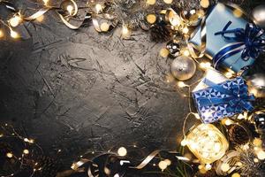 kerstcadeau met blauw lint en kerstversiering ballen op abstracte bokeh zwarte achtergrond met kopie ruimte. vakantie achtergrond wenskaart voor vrolijk kerstfeest en nieuwjaar.