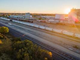 industrieel treinwisselgebied bij zonsondergang in de herfst met gloeiende zon foto