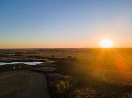 geweldige zonsondergang over boerderijveld in de herfst in het middenwesten foto