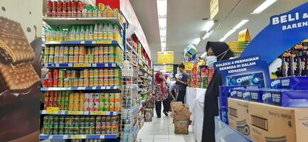 klant kiezen divers boodschappen producten in kruidenier op te slaan. supermarkt concept. bekasi, west Java, Indonesië - maart 8 2024 foto