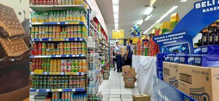 klant kiezen divers boodschappen producten in kruidenier op te slaan. supermarkt concept. bekasi, west Java, Indonesië - maart 8 2024 foto