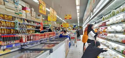 klant kiezen divers boodschappen producten in kruidenier op te slaan. supermarkt concept. bekasi, west Java, Indonesië - maart 8 2024 foto