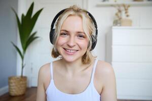 concept van mensen en levensstijl, dichtbij omhoog van mooi blond vrouw in draadloze koptelefoon, luistert naar muziek, geniet mooi zo kwaliteit geluid in nieuw oortelefoons foto