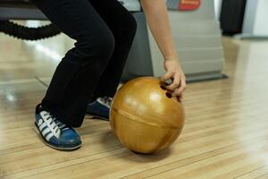 jong meisje hebben pret met bal in bowling club. foto