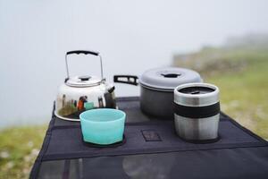 camping tafel kookgerei, thee bril, metaal gebruiksvoorwerpen, camping pan, klein ketel, keuken uitrusting foto