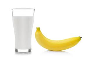 glas melk met banaan op witte achtergrond foto